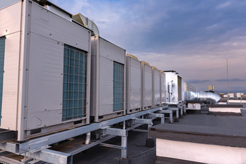 Air conditioner units VRV (HVAC), big fan and a water cooler on a roof of new industrial building...