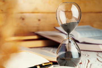 Hourglass with sand close up on wooden background