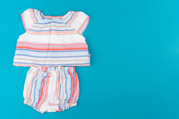 baby clothes on blue  background top view