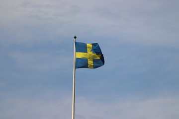 Flag of sweden blowing in the wind in stockholm on holiday. Travelling with cruise ship in summer.