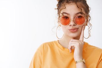 Close-up stylish glamour young redhead female student wear sunglasses orange t-shirt fold lips thoughtful have desire thinking touch cheek thoughtful make assumption, standing white background