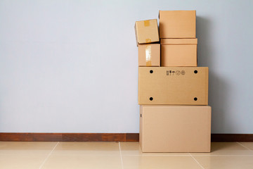 Cardboard boxes for moving on the floor against grey wall