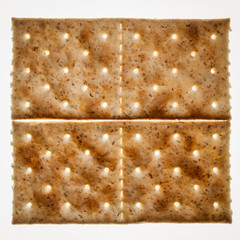 Two crackers close-up on a white background.