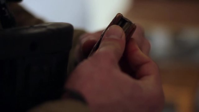 Male hands insert live ammunition into an assault rifle magazine. close-up, HD, no sound