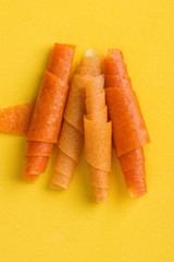 fruit rolls of orange, mango, banana on a yellow background close-up