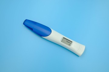 Digital pregnancy test with weeks estimator over blue background