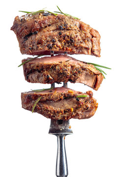 Beef steak on a fork isolated on a white background.