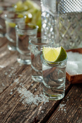 Tequila with  salt and lime on a old wooden background.