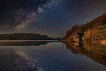 Stunning majestic digital composite landscape of Milky Way over Ullswater in Lake District