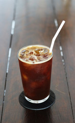 Black coffee with ice on table in cafe.