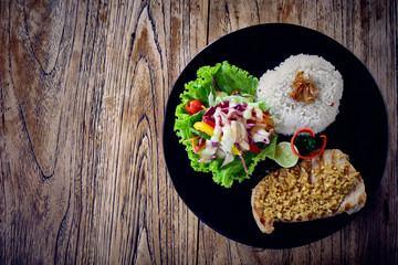 Grilled tuna steak with rice and vegetables on a wooden table. Top view.
