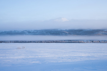 foggy morning over a frozen lake in sweden