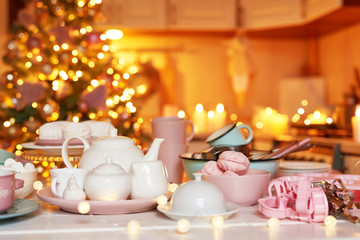 Obraz na płótnie Canvas Christmas decor in kitchen. Christmas dishes and sweets. Bright interior of New Year's kitchen. New year card template. The kitchen is white and pink colors. Christmas tree in the kitchen