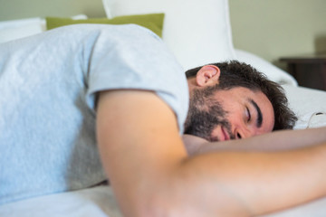 Fototapeta na wymiar Young man sleeping in bed