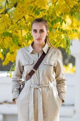 Fototapeta premium Three quarter length portrait of blonde person in a jumpsuit in public Park