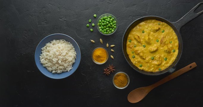 Cinemagraph loop. Cooking tasty chicken curry dish with rice in a cast iron pan