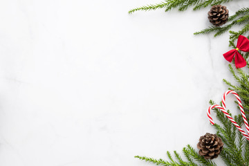 White marble table with Christmas decoration including pine branches and pine cones. Merry Christmas and happy new year concept. Top view with copy space, flat lay.