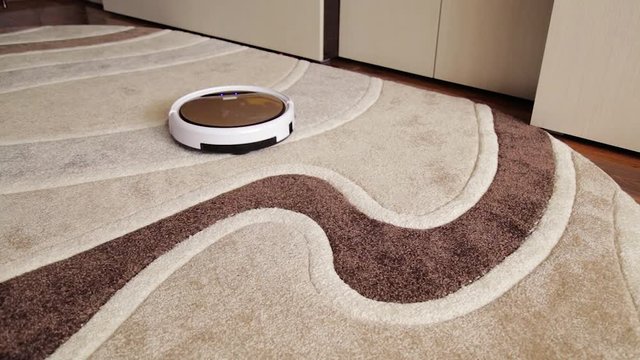 Robot vacuum cleaner cleans the floor from dust. Smart house.