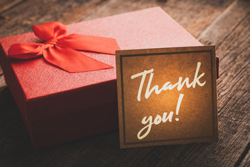 Gift box with a note of gratitude on a wooden table in vintage processing: concept of expression of...