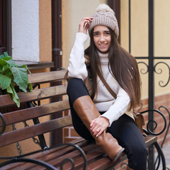 Lifestyle portrait of a beautiful brunette girl in hat. Outdoor shot of people emotions.