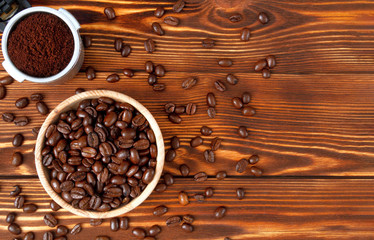Wooden plate with coffee grains, ground coffee in a horn on a wooden table.Copy space.Top view.   