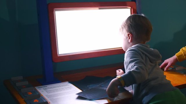 Home education, self-isolation at home COVID-19. Mental relocation of children. Boy puts x-ray pictures on the light screen.