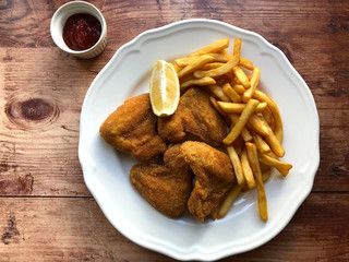 Breaded crispy chicken with french fries and sauce.