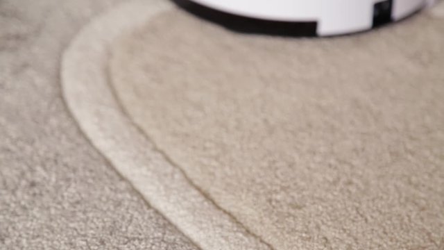 Robot vacuum cleaner cleans the floor from dust. Smart house.