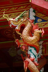 Fototapeta premium The golden dragon statue on pole in the temple