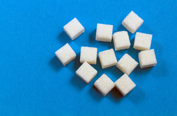 Cubes of white sugar on a blue background.
