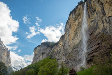 Obraz premium Staubbach waterfall in Lauterbrunnen on blue sky with clouds background with copy space , Switzerland