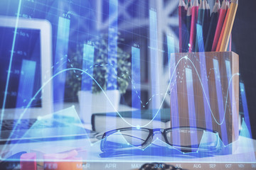 Financial chart hologram with glasses on the table background. Concept of business. Double exposure.