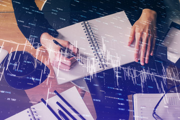 Forex graph on hand taking notes background. Concept of research. Multi exposure