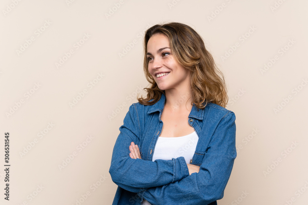 Wall mural young blonde woman over isolated background looking to the side