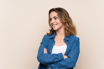 Young blonde woman over isolated background looking to the side