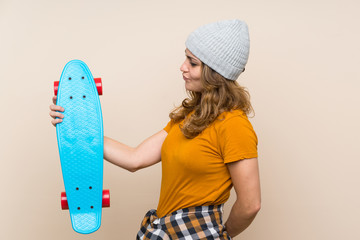 Young skater blonde girl over isolated background with happy expression