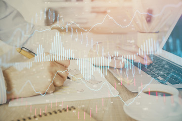 Multi exposure of stock market graph with man working on laptop on background. Concept of financial analysis.