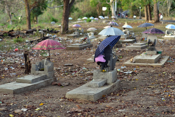 Umbrellas over graves and coffins at Nusa Lembongan Island cemetery, Bali, Indonesia