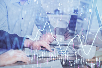 Multi exposure of chart with man typing on computer in office on background. Concept of hard work.