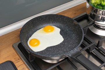 Frying pan with fried eggs. Cooking of delicious eggs