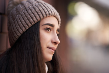 Lifestyle portrait of a beautiful brunette girl in hat. Outdoor shot of people emotions.