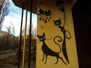 entrance to the apartment building with painted cats
