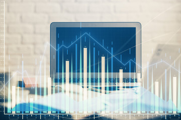 Stock market graph on background with desk and personal computer. Double exposure. Concept of financial analysis.