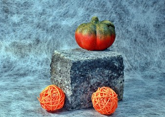 lightly decorated concrete stone with pumpkin and bast balls