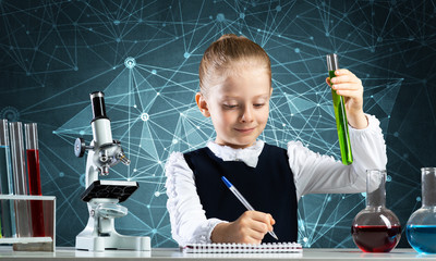 Little girl scientist examining test tube