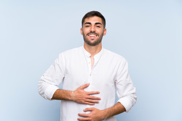 Handsome man with beard over isolated blue background smiling a lot