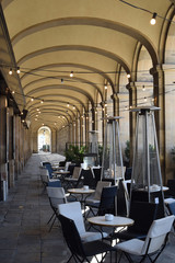 Empty Tables & Chairs in Outdoor Restaurant Under Arcade