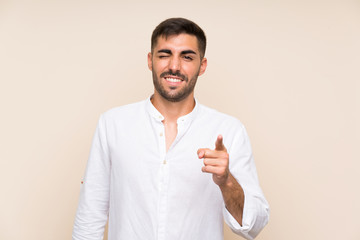 Handsome man with beard over isolated background points finger at you