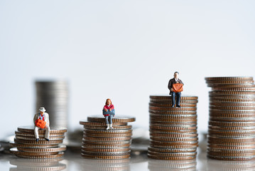Miniature people: Elderly people sitting on coins stack. Retirement planning. money saving and Investment. Time counting down for retirement concept. - obrazy, fototapety, plakaty