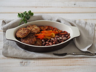 cutlets in a plate with ingredients on a white wooden table